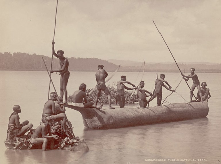 Group of andaman men and women in costume some wearing body paint and with bows and arrows catching turtles from boat on water - The Indigenous Islanders Of India | Nature inFocus
